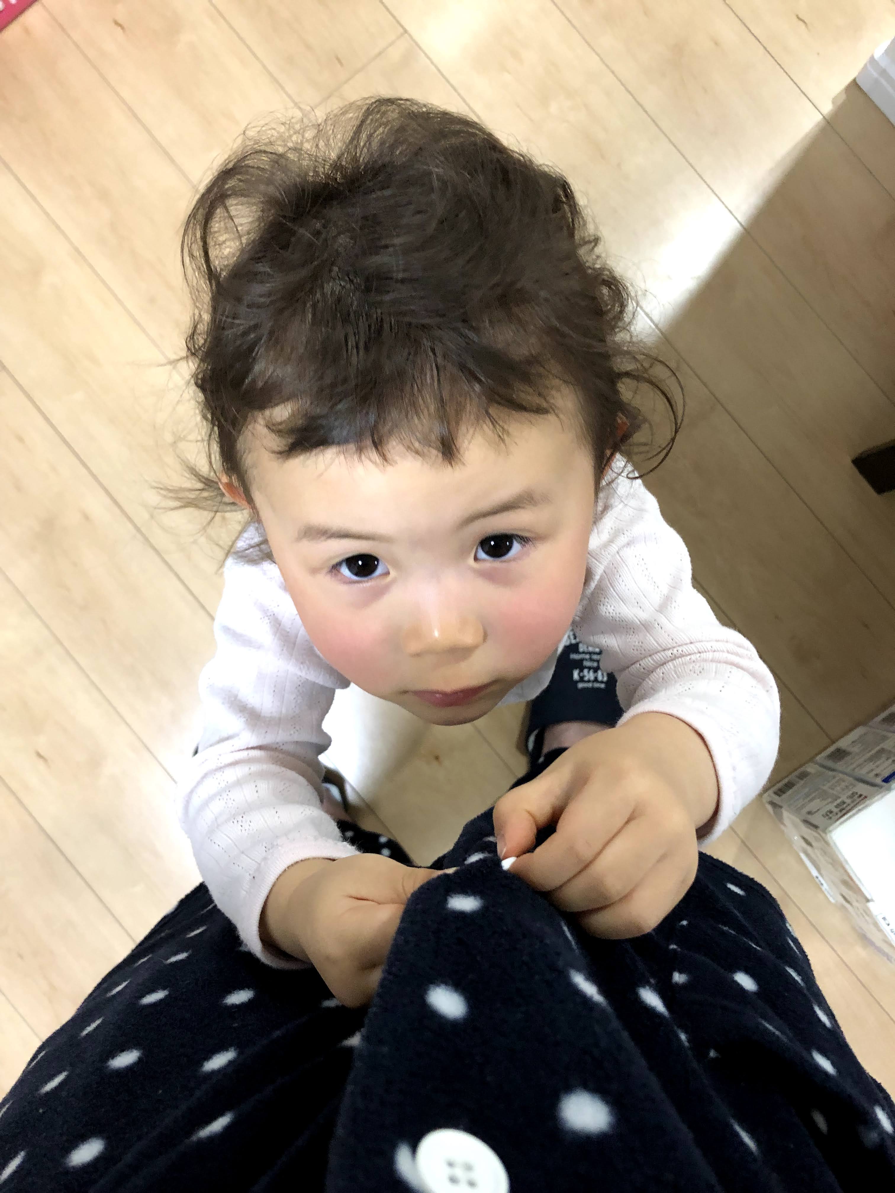 パジャマのボタンを留めてくれている子ども