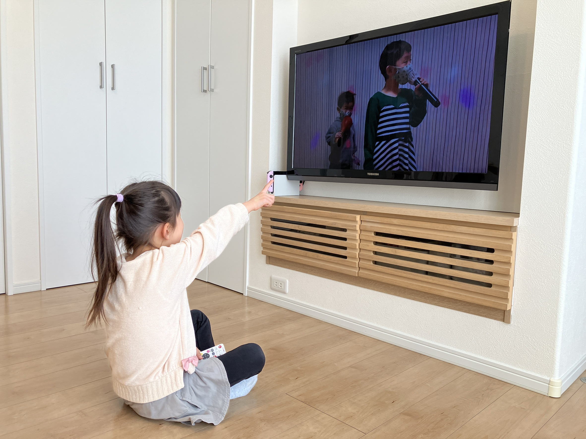 自分でリモコンを操作して写真を楽しむ子ども